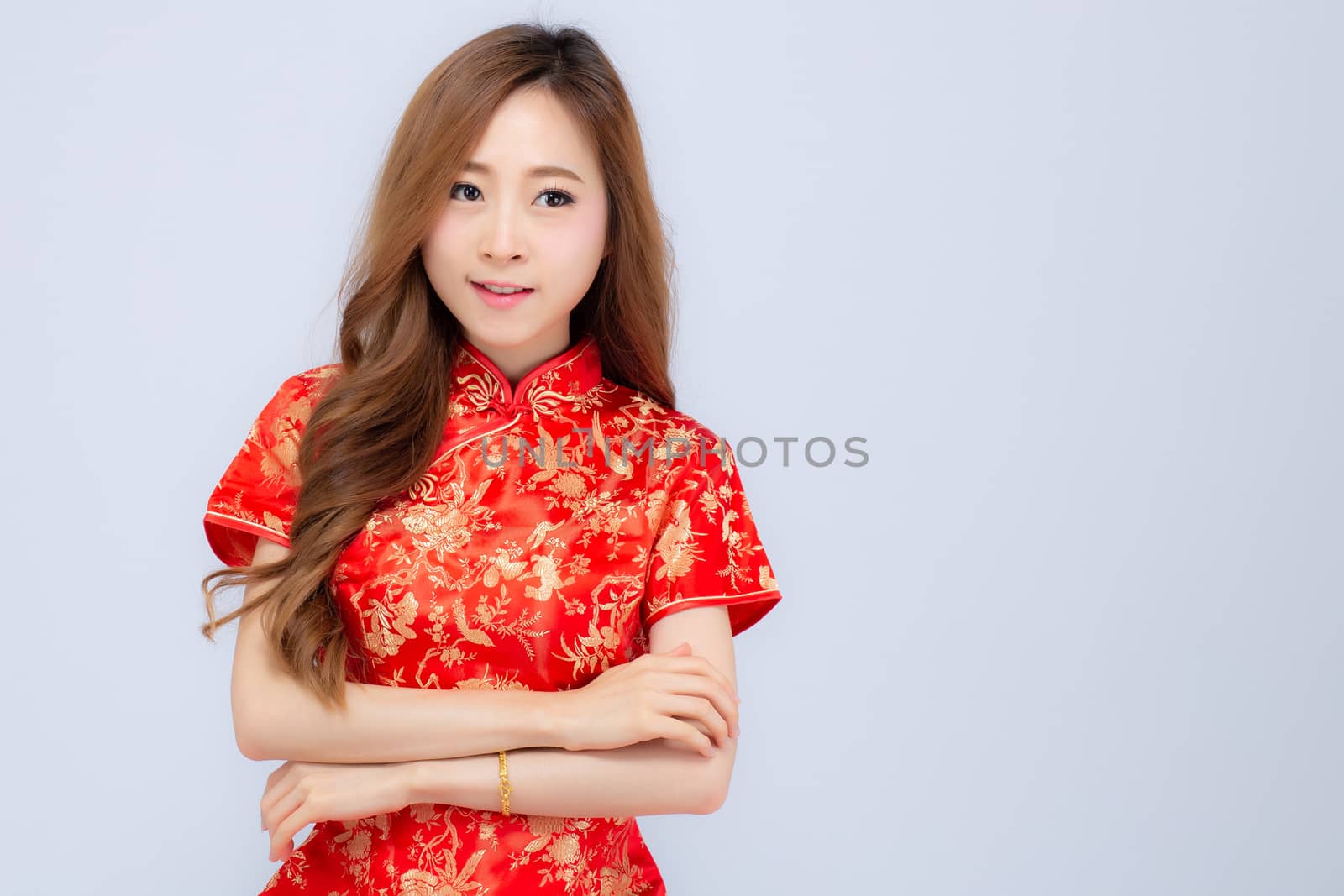 Beautiful portrait happy Chinese New Year young asian woman wear cheongsam smile with gesture congratulation and greeting isolated on white background, festival and celebrate concept.