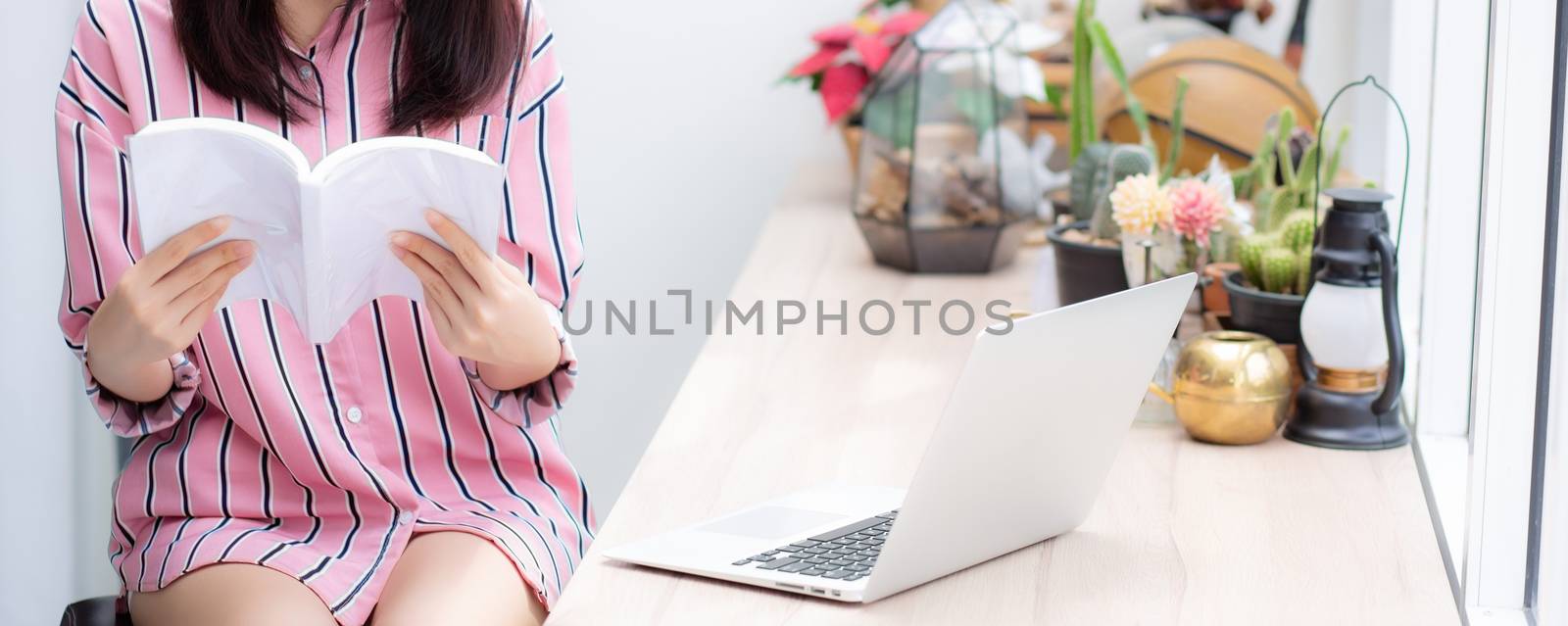 Closeup asian woman relax sitting reading book in living room at home, girl study literature, education and llifestyle concept.