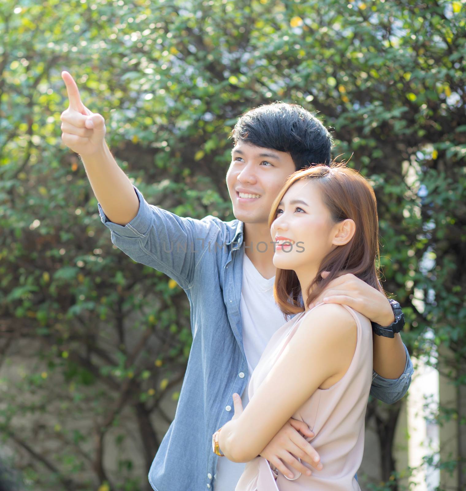 Beautiful portrait couple looking each others eyes and smiling with happy, young asian man and woman relation pointing something, husband and wife feeling and emotion, lovers and lifestyle concept.