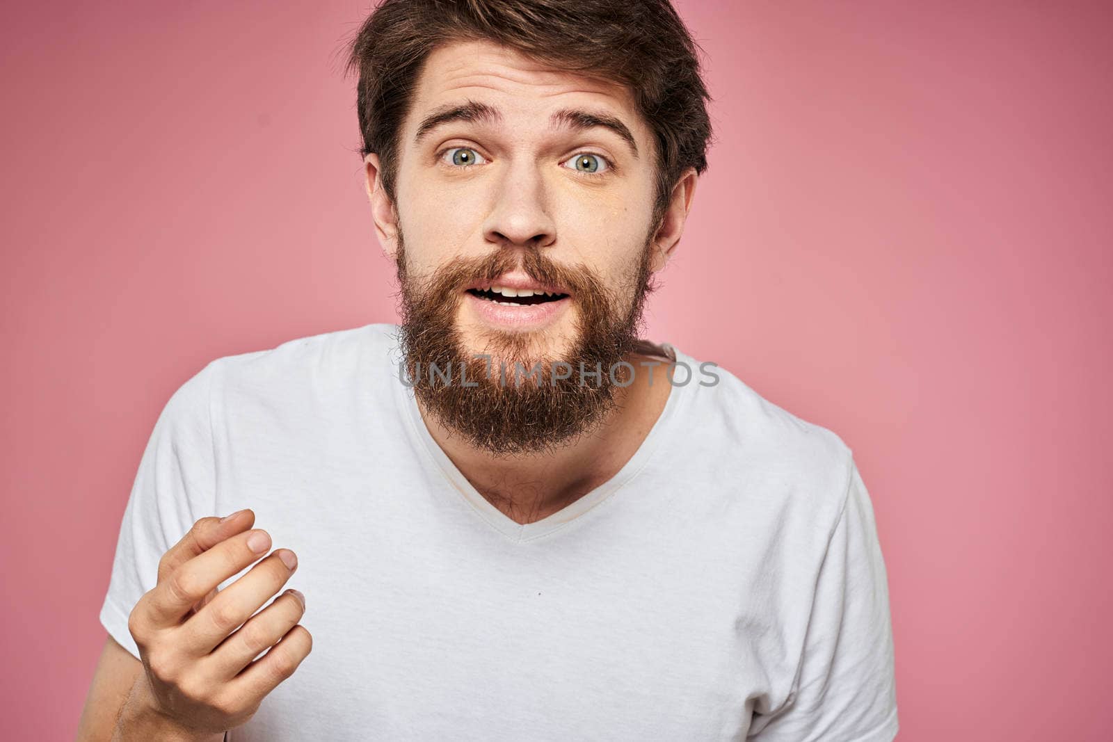 Man in white t-shirt emotions lifestyle facial expression cropped view pink background. by SHOTPRIME