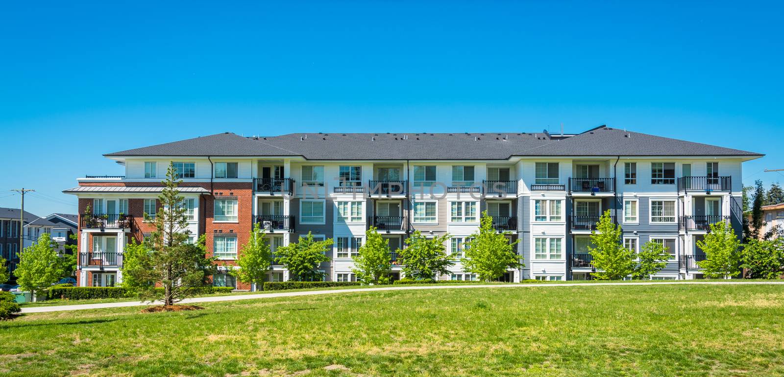 Brand new apartment building on sunny day in British Columbia, Canada. by Imagenet