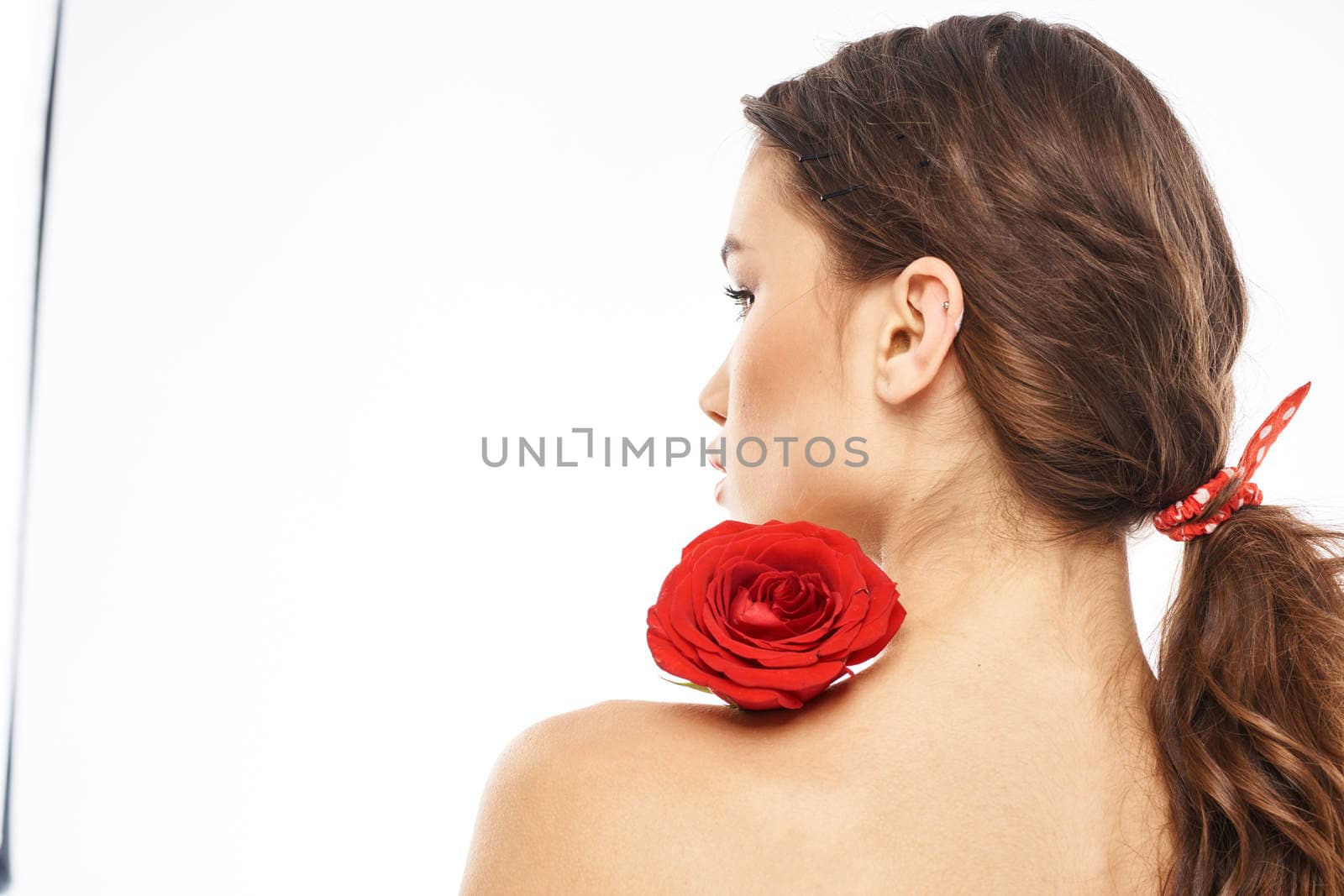 Portrait of woman with red rose naked shoulders Make-up on brunette face. High quality photo