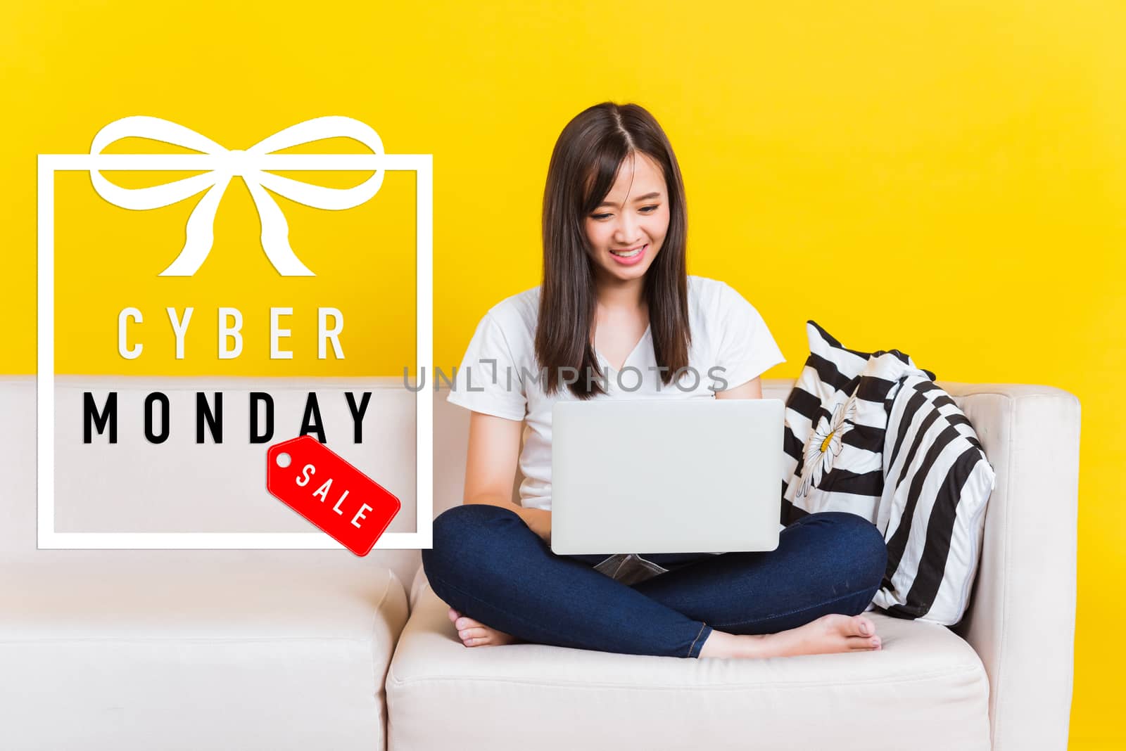 woman shopping online, sitting on sofa using laptop computer by Sorapop