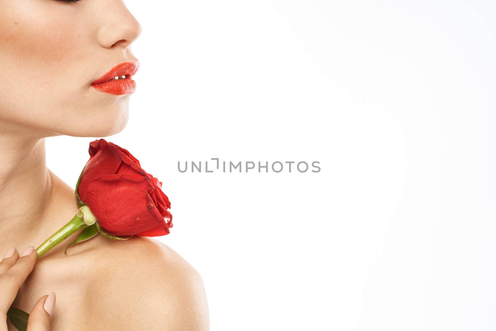 charming brunette girl with makeup on her face and a red rose in her hand. High quality photo