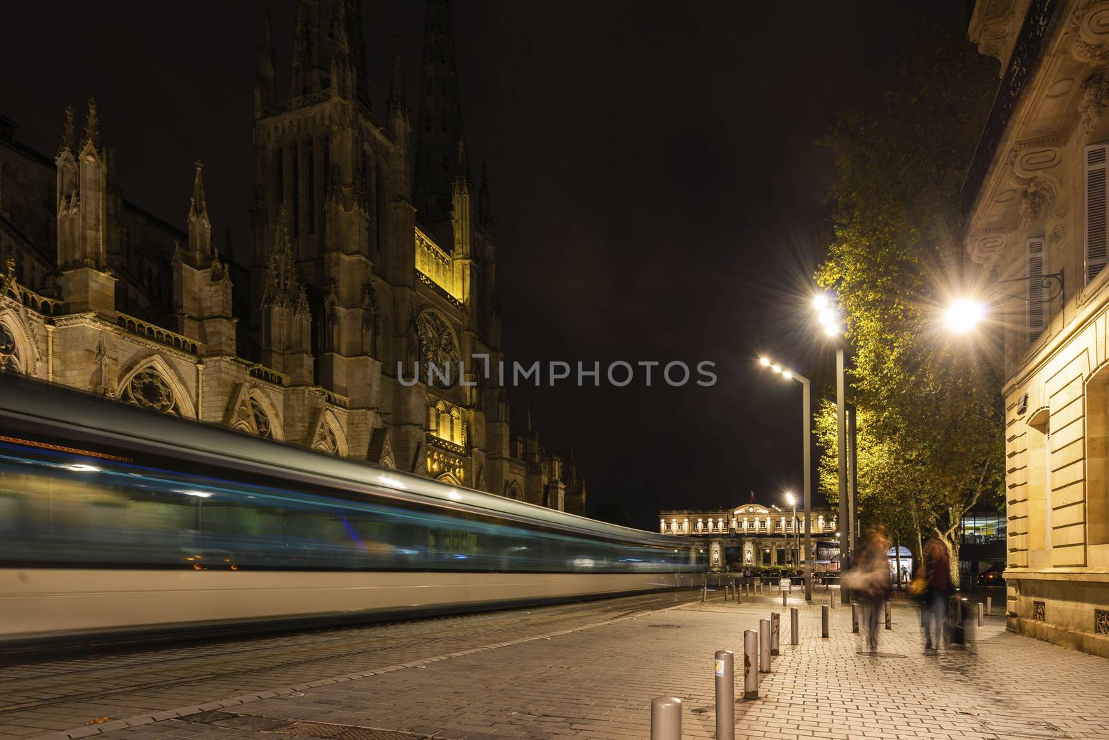 The tram passing in front of Saint-André Cathedral in Bordeaux at night. by Frederic