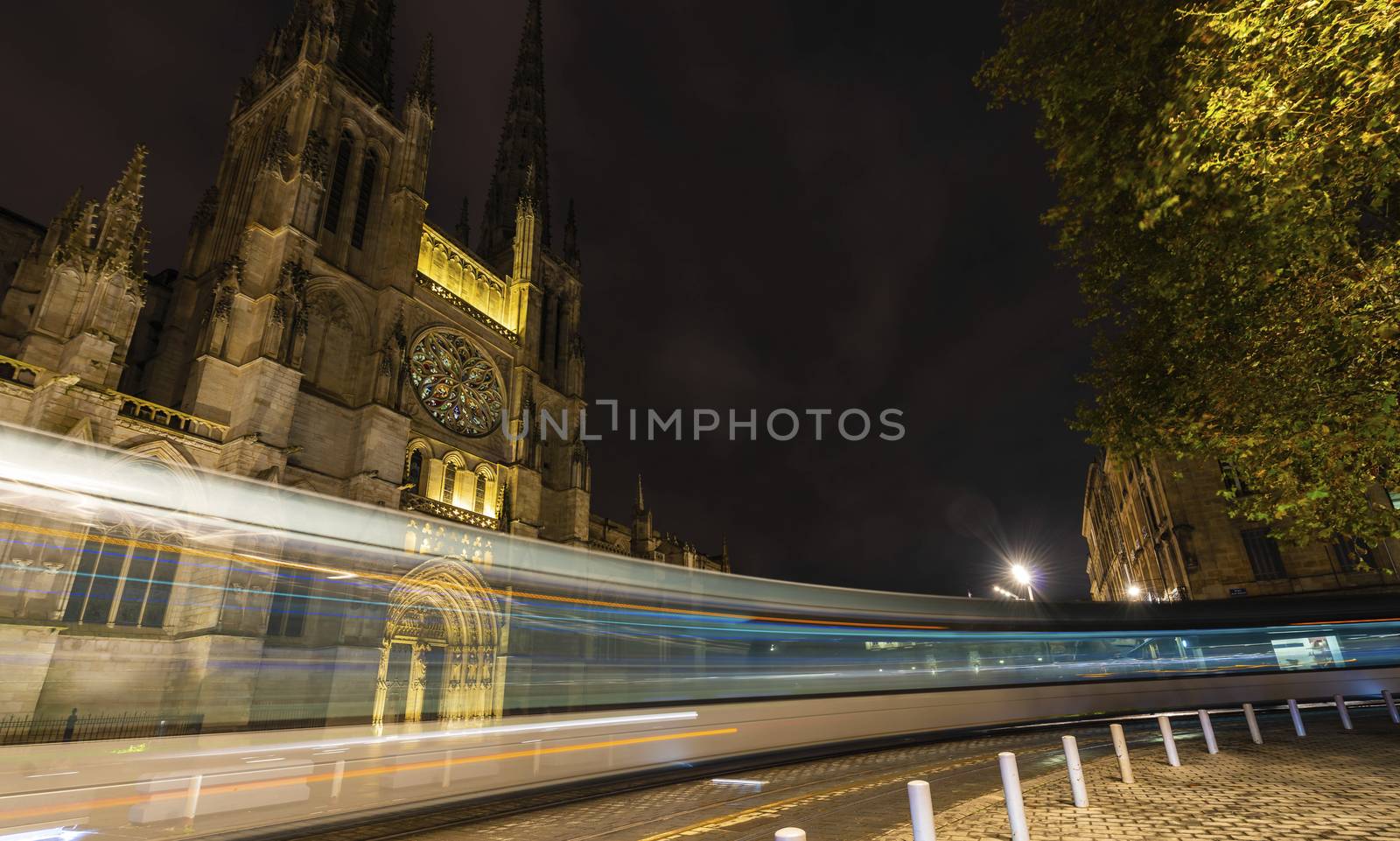 The tram passing in front of Saint-André Cathedral in Bordeaux at night. by Frederic