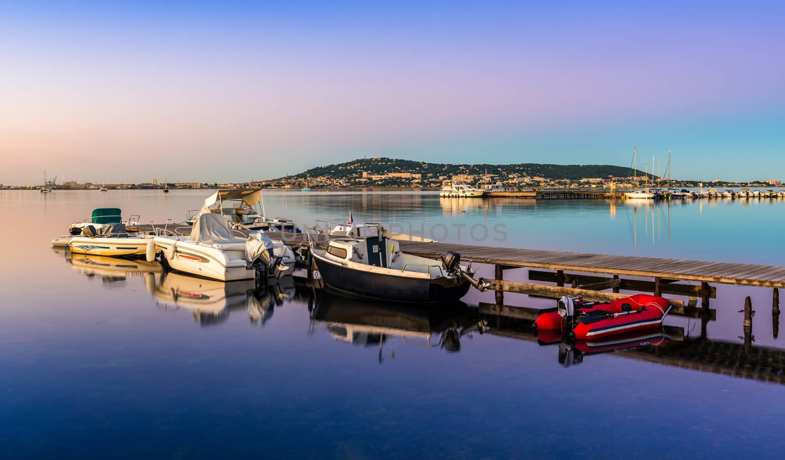 Pontoon with boats in Balaruc-les-Bains, on the Etang de Thau, and Sète in the background. by Frederic