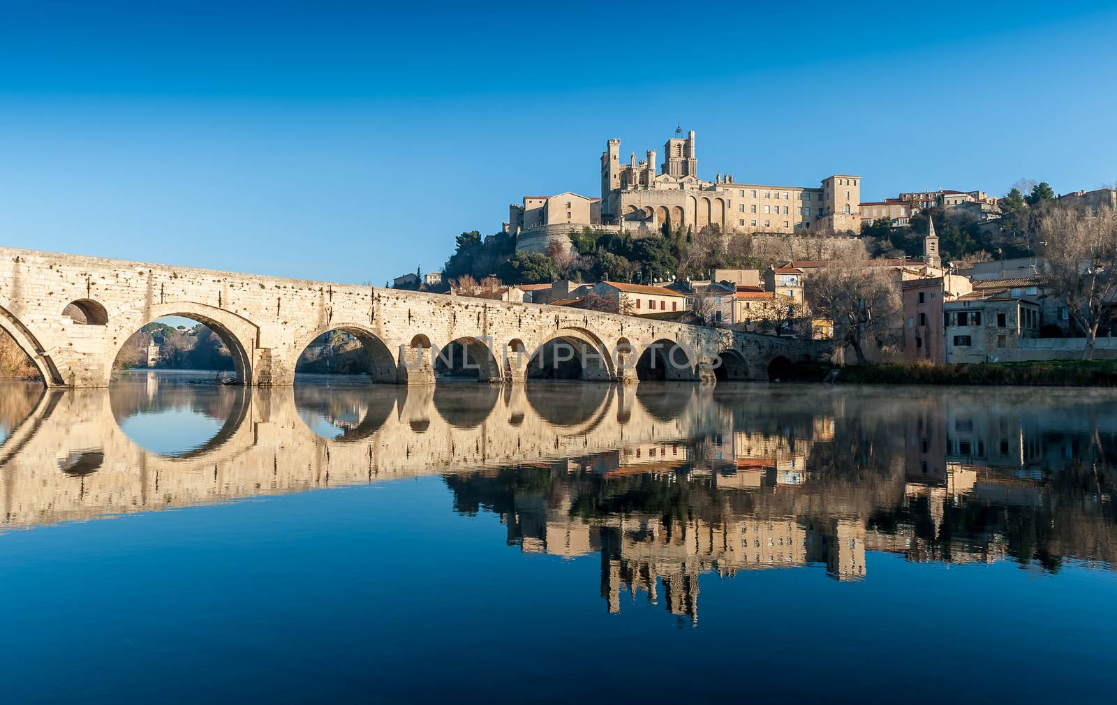 Magnificent view of the old bridge and the Saint-Nazaire cathedral in Béziers over the river Orb. by Frederic