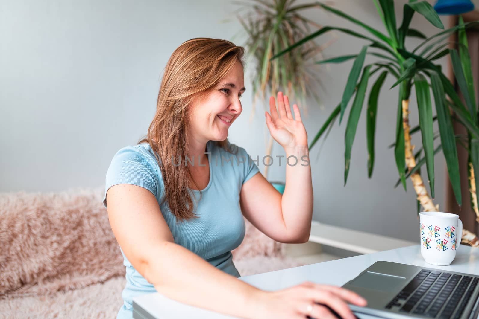 Middle age woman sitting at the table at home working using computer laptop. Work from home and stay at home during coronovirus pandemic concept