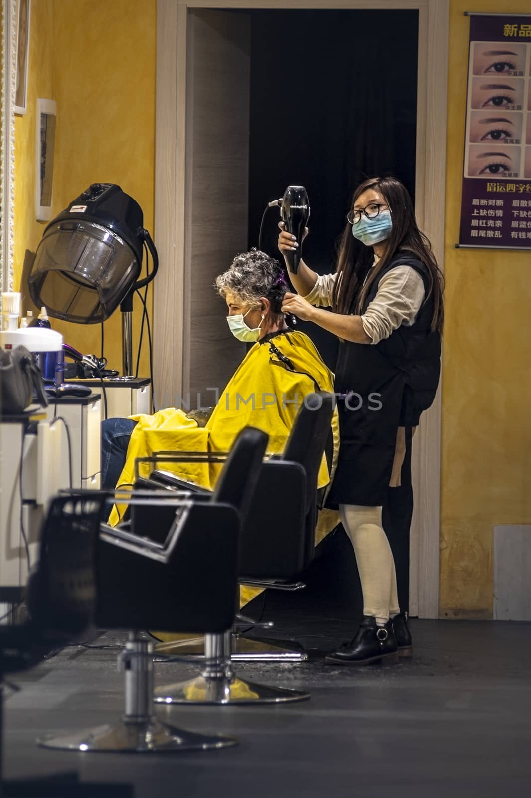 hairdresser who gives hair to a client with medical masks by carfedeph