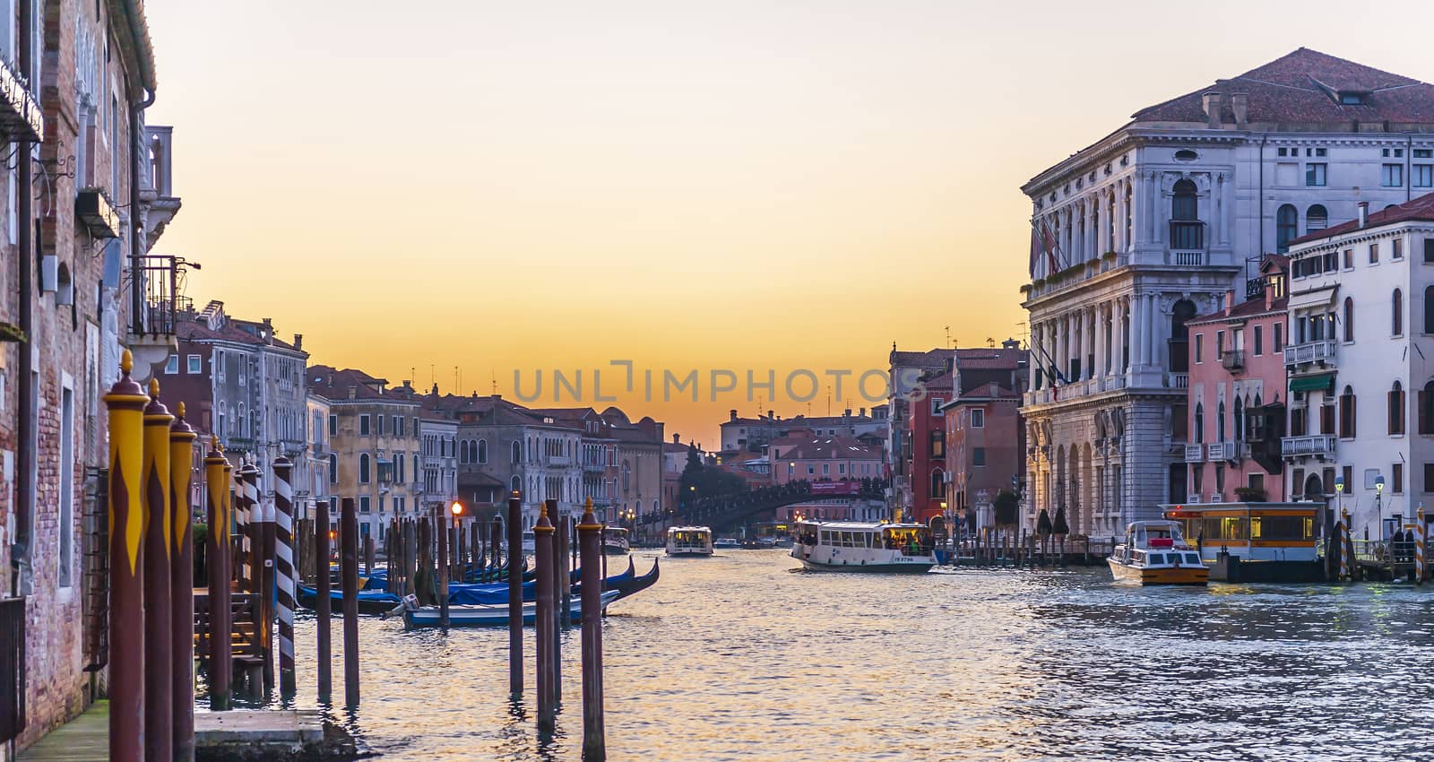 Panorama of the Grand Canal at dusk and its traffic, with its typical facades and gondolas in Venice in Veneto, Italy by Frederic