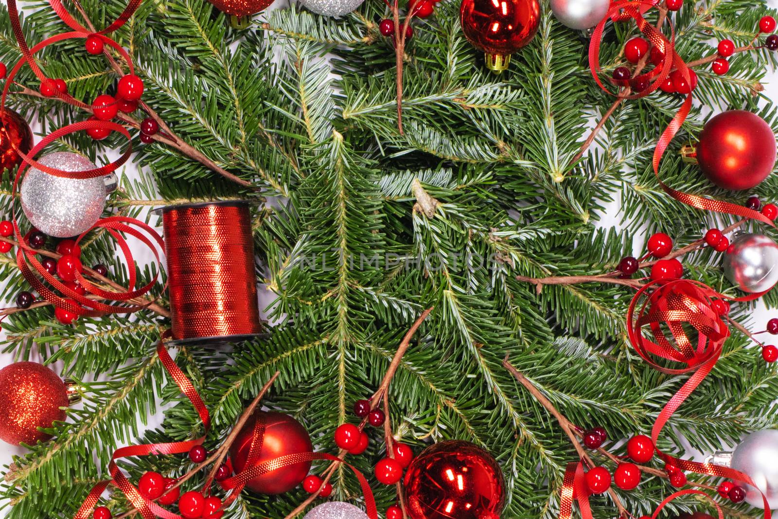 Christmas copmosition of fir tree branch and red decorations balls baubles pine ribbons background