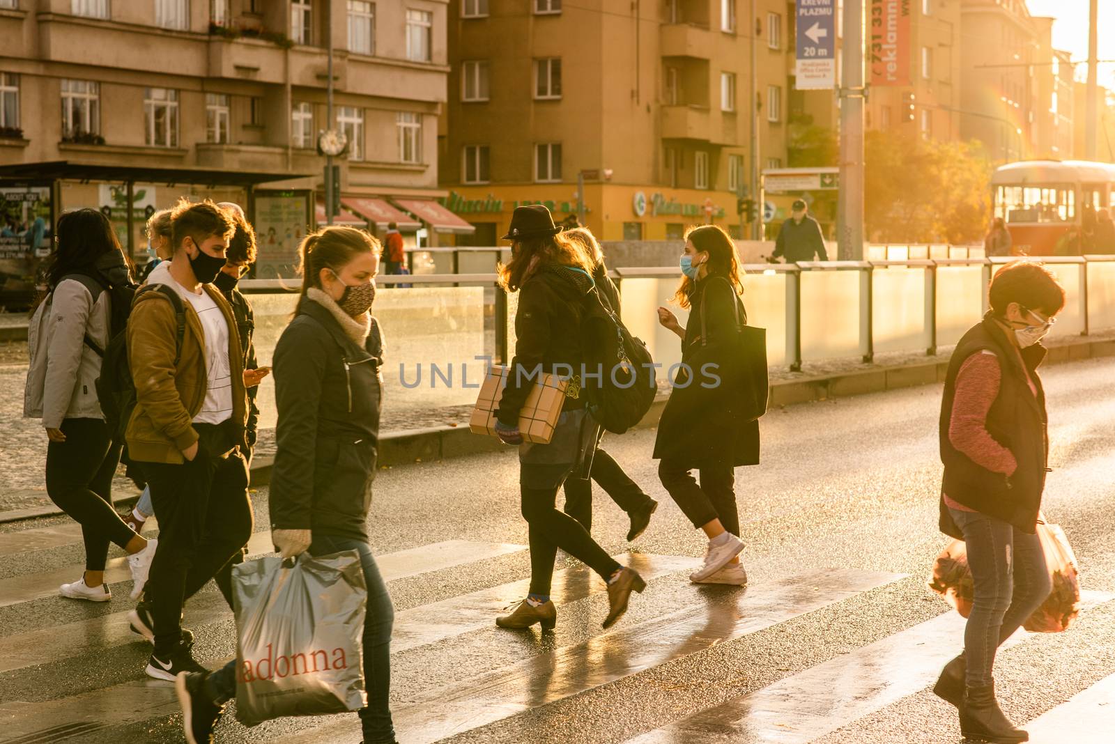 People with mask is crossing the street at Hradcanska metro station during quarantine period due to outbreak of COVID-19 as winter is starting. Prague, Czech Republic