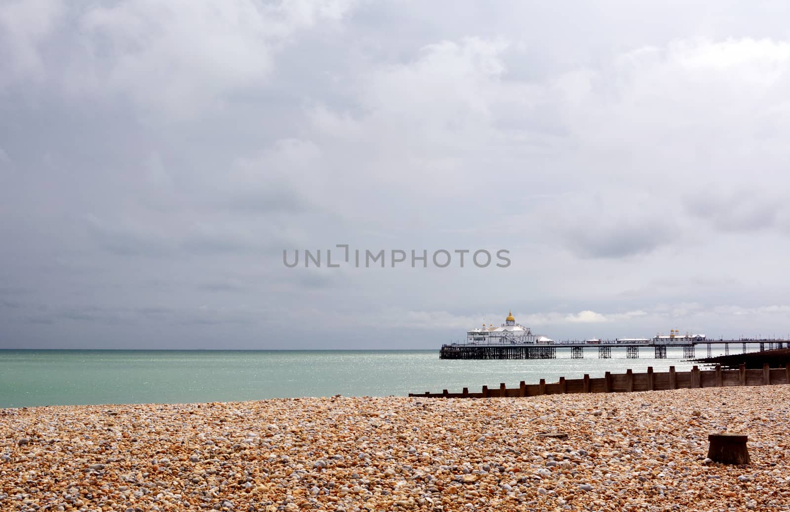 View across pebble beach to Eastbourne pier on the English coast by sarahdoow