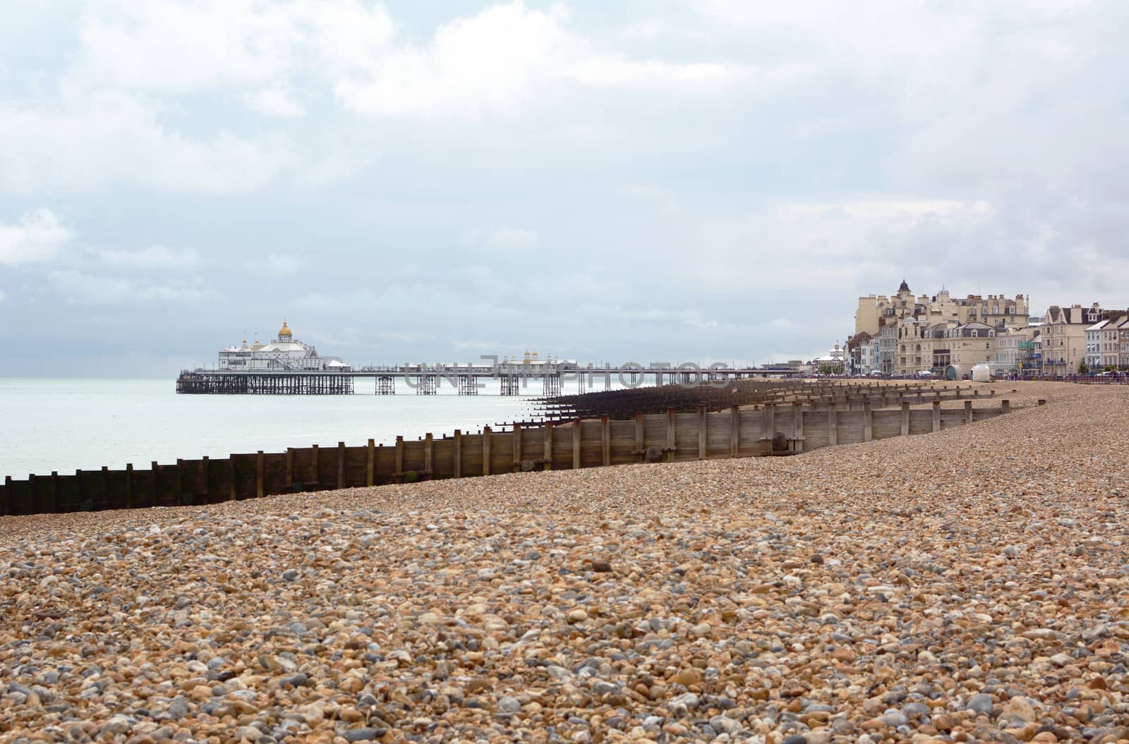 Eastbourne pebble beach in East Sussex with the famous Eastbourne pleasure pier above the sea in the distance