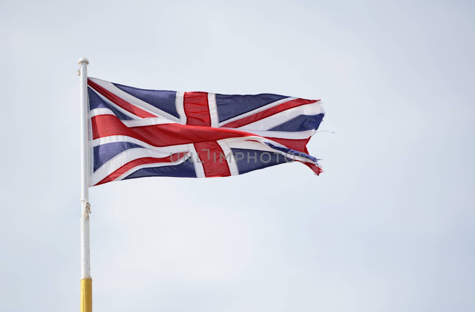 Union Jack flag representing Scotland, Wales, Northern Ireland and England, flies against a light blue sky