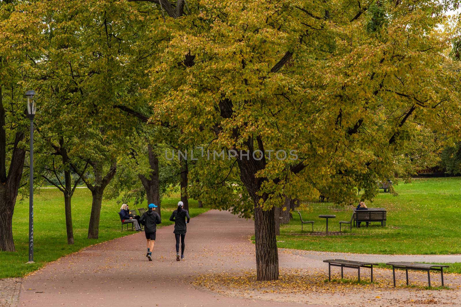 Man and woman are running and talking on Letna Park in Autumn 2020 on Prague 6, during quarantine period due to outbreak of COVID-19 as winter is starting, Czech Republic. Editorial.