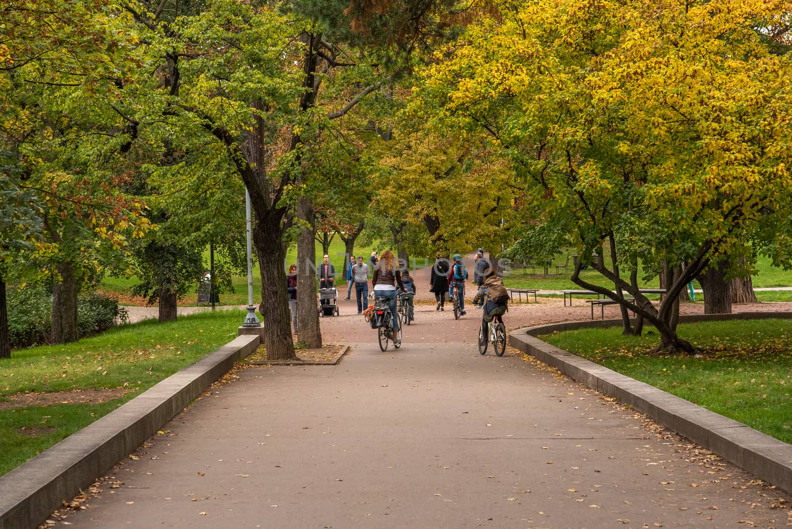 Group of friends are riding on bicycle and having a good time on Letna Park in Autumn 2020 on Prague 6, during quarantine period due to outbreak of COVID-19 as winter is starting, Czech Republic by gonzalobell