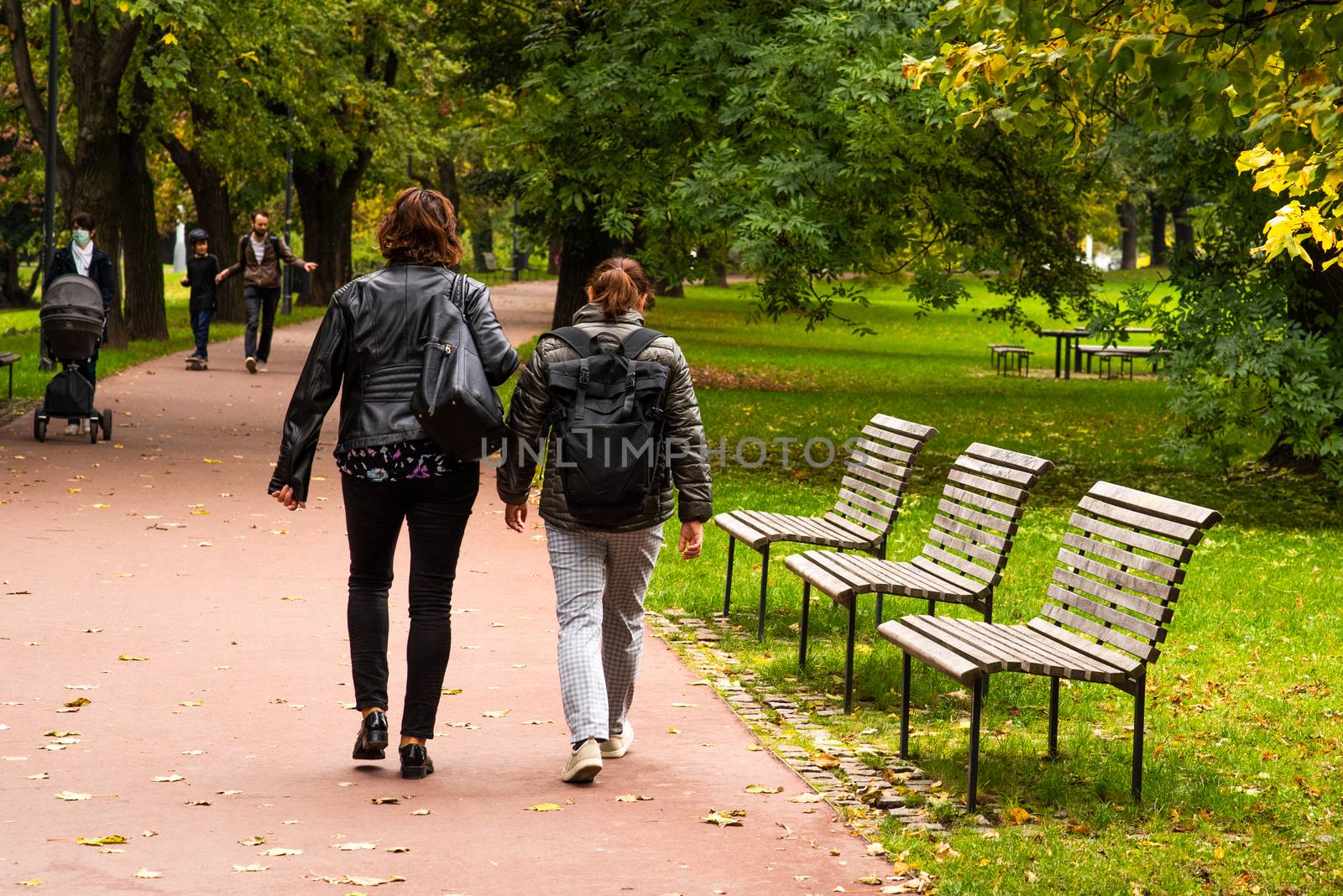 Two woman are walking and talking on Letna Park in Autumn 2020 on Prague 6, during quarantine period due to outbreak of COVID-19 as winter is starting, Czech Republic by gonzalobell