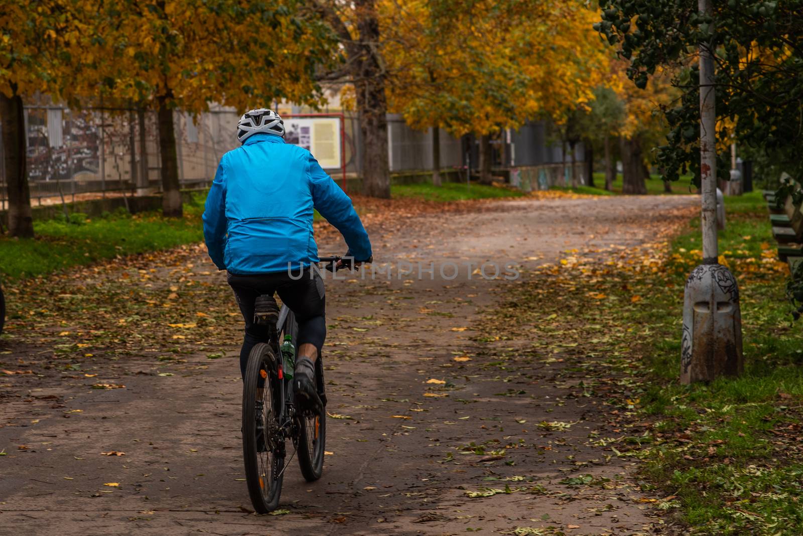 A man are is driving a bicycle on Stromovka Park in Autumn 2020 on Prague 6, during quarantine period due to outbreak of COVID-19 as winter is starting, Czech Republic