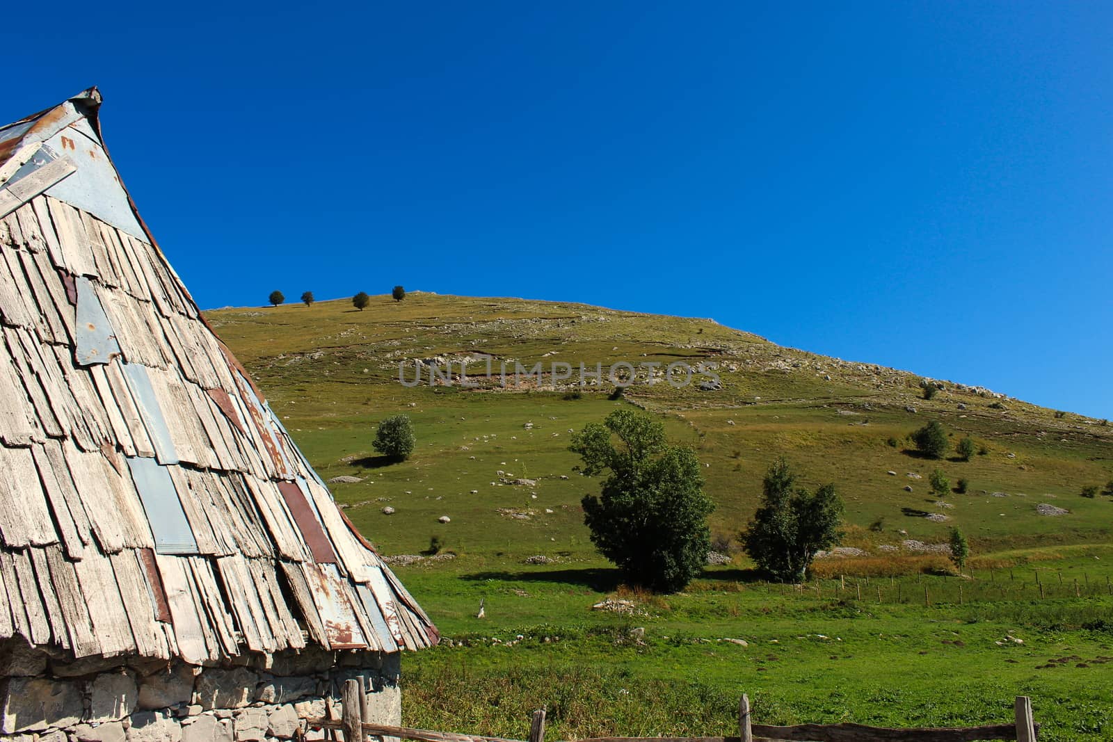 Part of the house and the roof of a Bosnian house with a view of the hill behind, in the old Bosnian village of Lukomir on the Bjelasnica mountain.