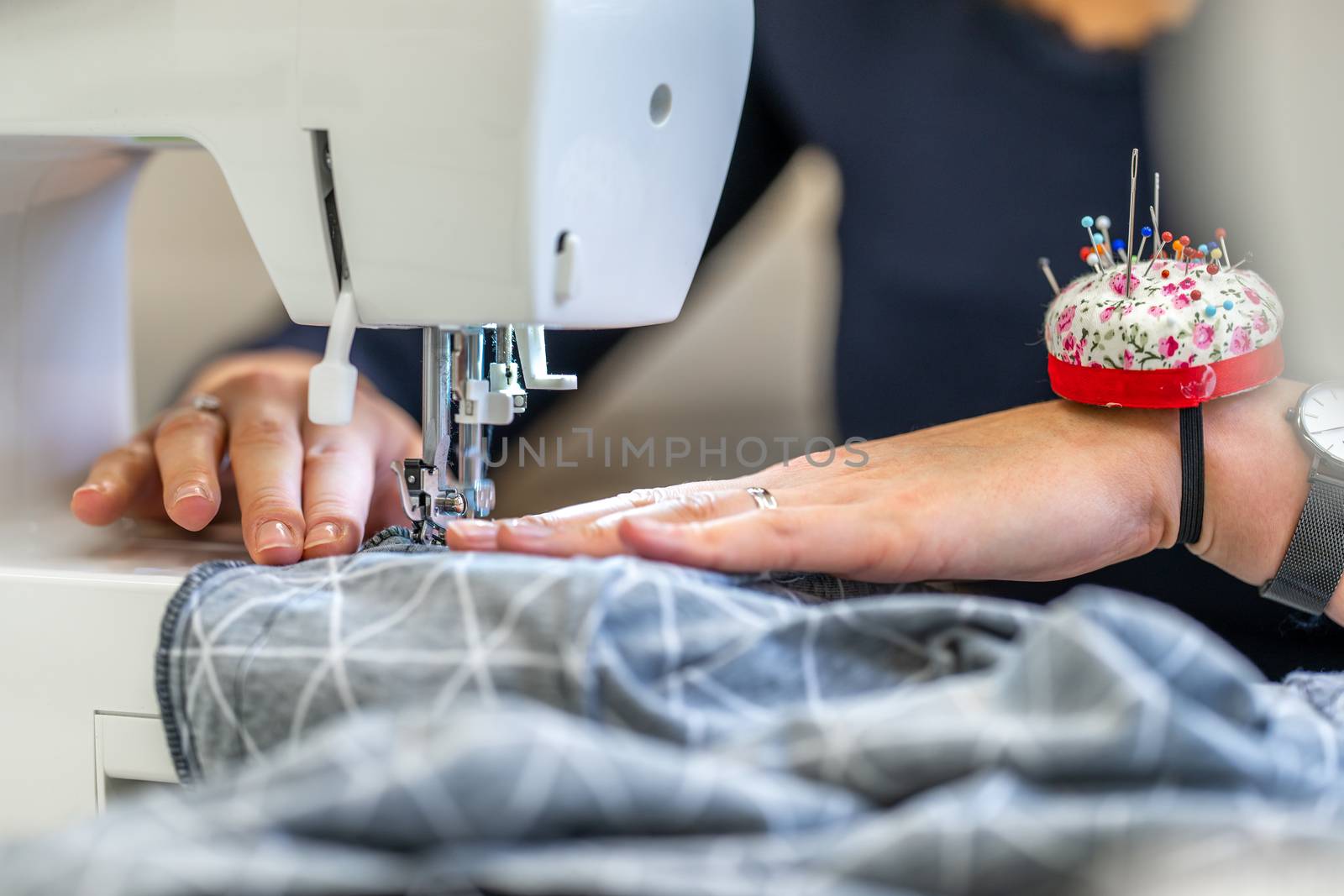 sewing cloth on a sewing machine in a tailor shop by Edophoto
