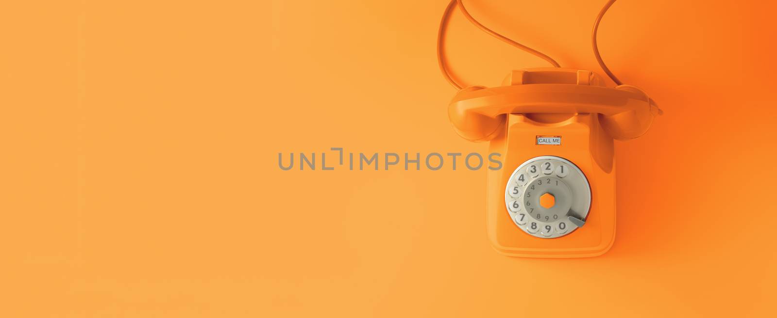 An orange vintage dial telephone with orange background.