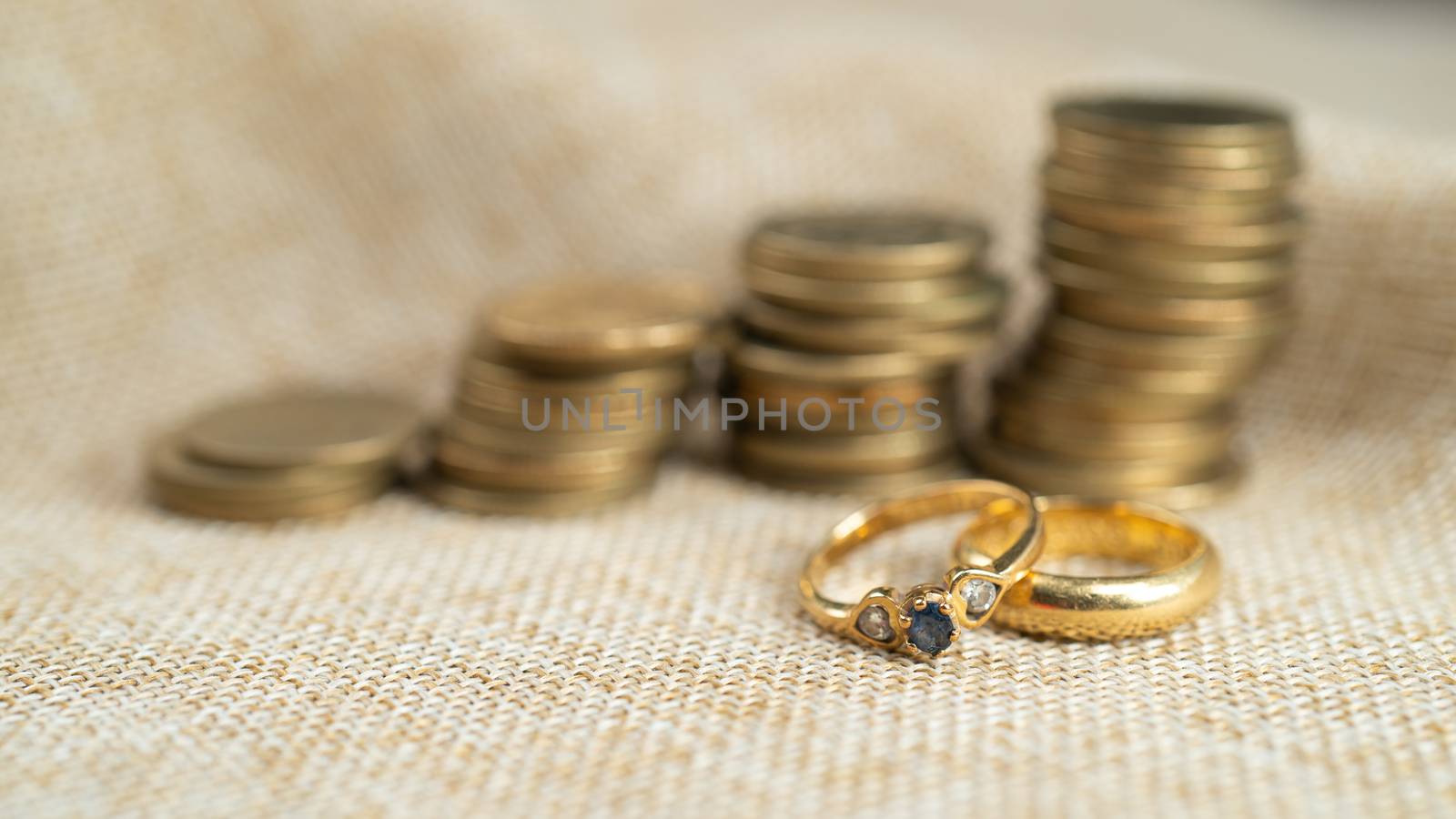Wedding rings with stack of coins, saving money for marry.