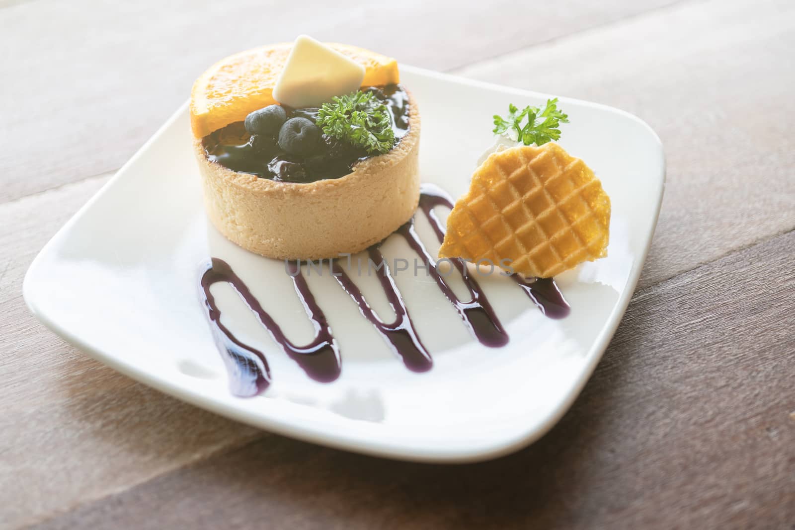 Blueberry tart on the table. Closeup of tartlets Served with fresh orange sliced.