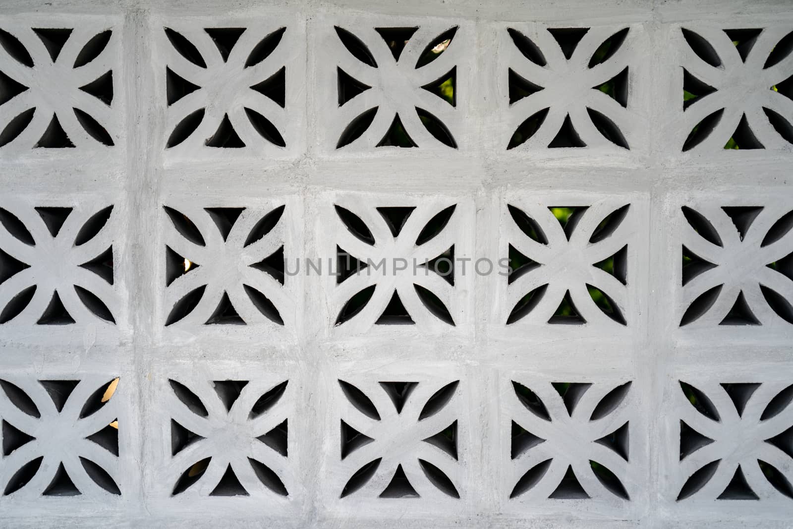 Flower fretwork brick pattern, perforated framework background, texture on white brick wall.