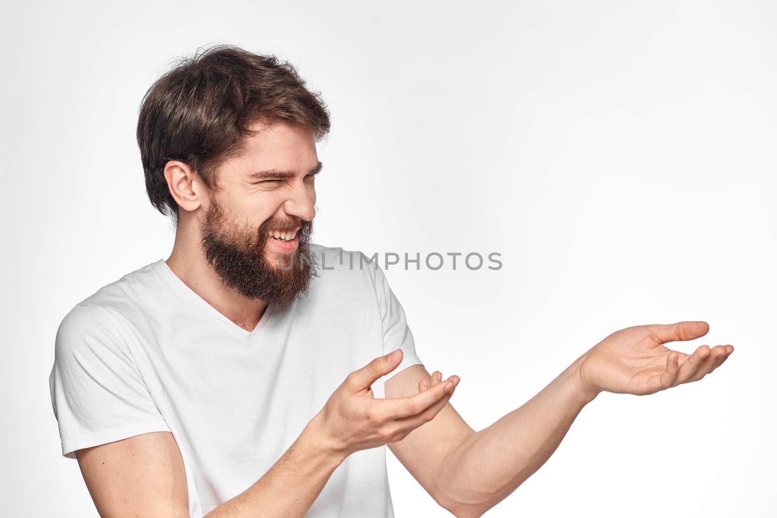 cheerful emotional bearded man gesturing with his hands close-up light background. High quality photo