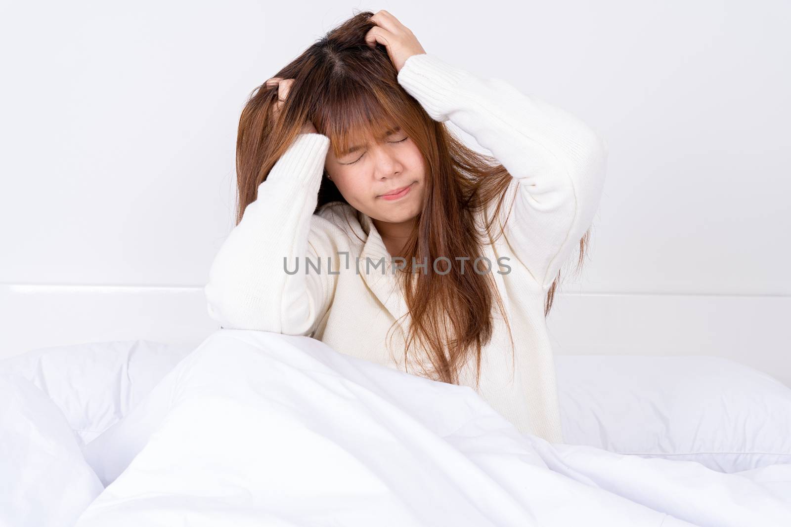 Young woman suffering from headaches after wake up on the bed. Healthcare medical or daily life concept. by mikesaran