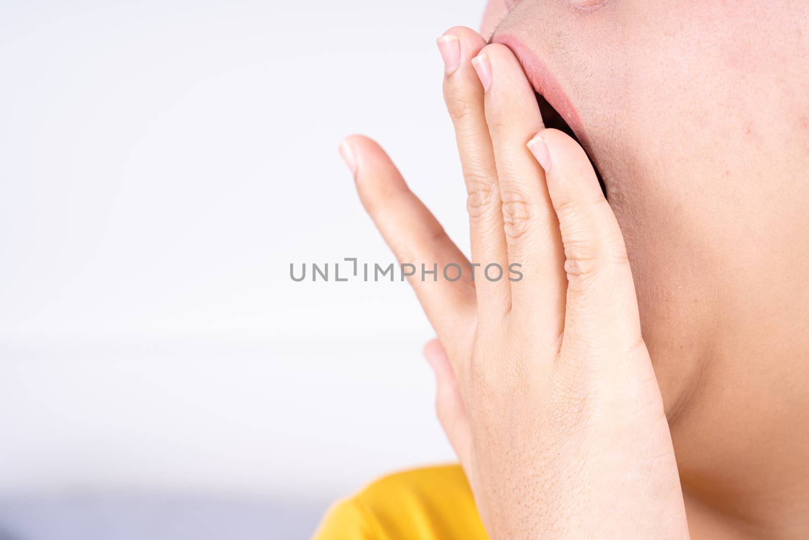 Asian woman are yawning covering open mouth with hand after she wake up. Healthcare medical or daily life concept.