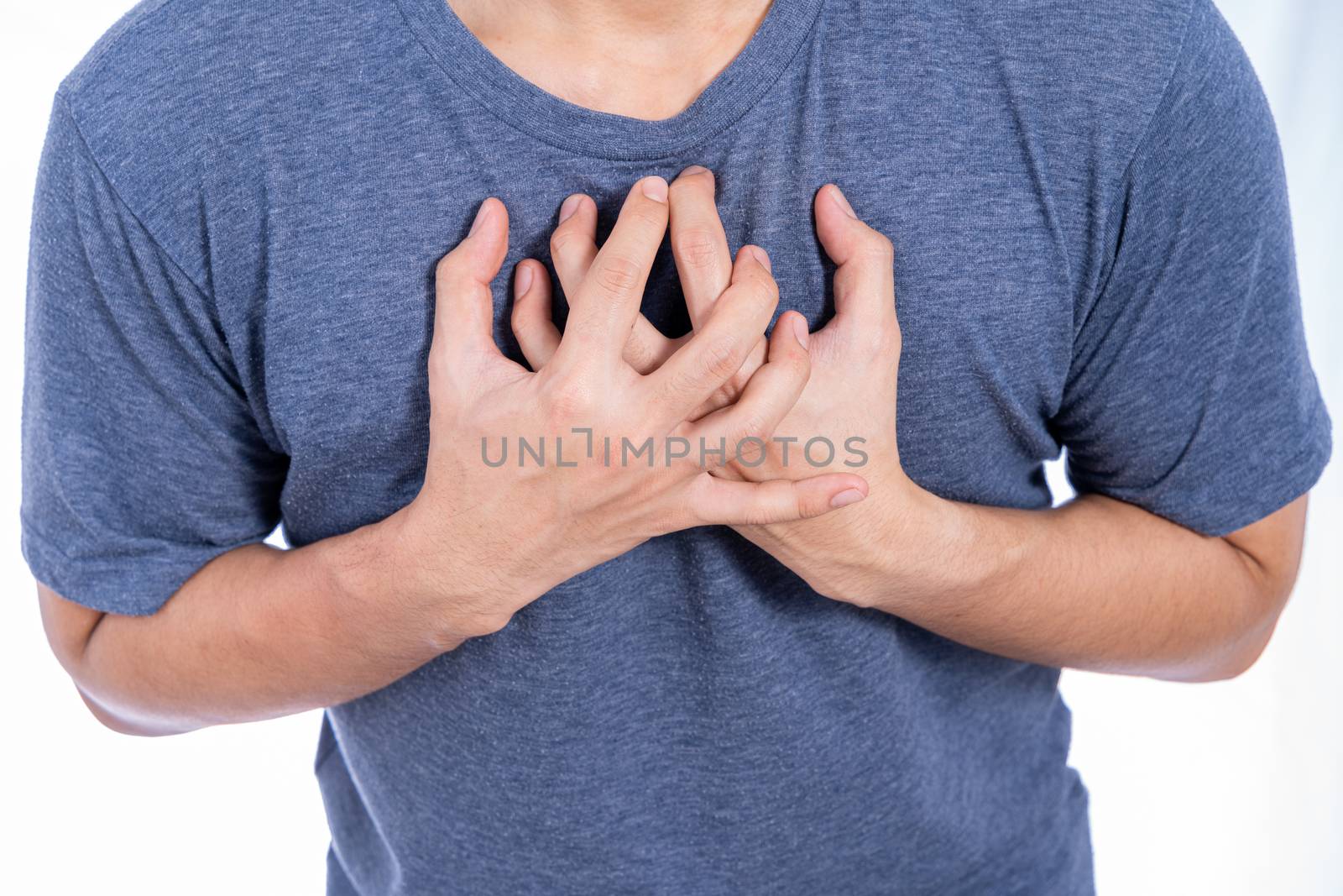 Man touching his heart or chest isolated white background. Healthcare medical or daily life concept.