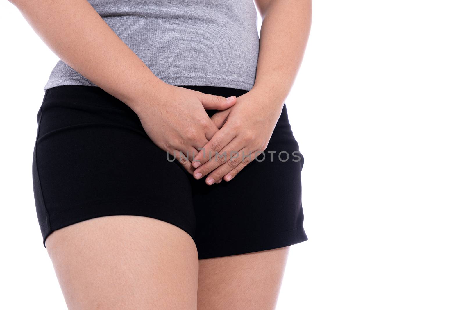 Woman hands holding her crotch suffering from painful stomachache isolated white background. Medical, healthcare for advertising concept. by mikesaran