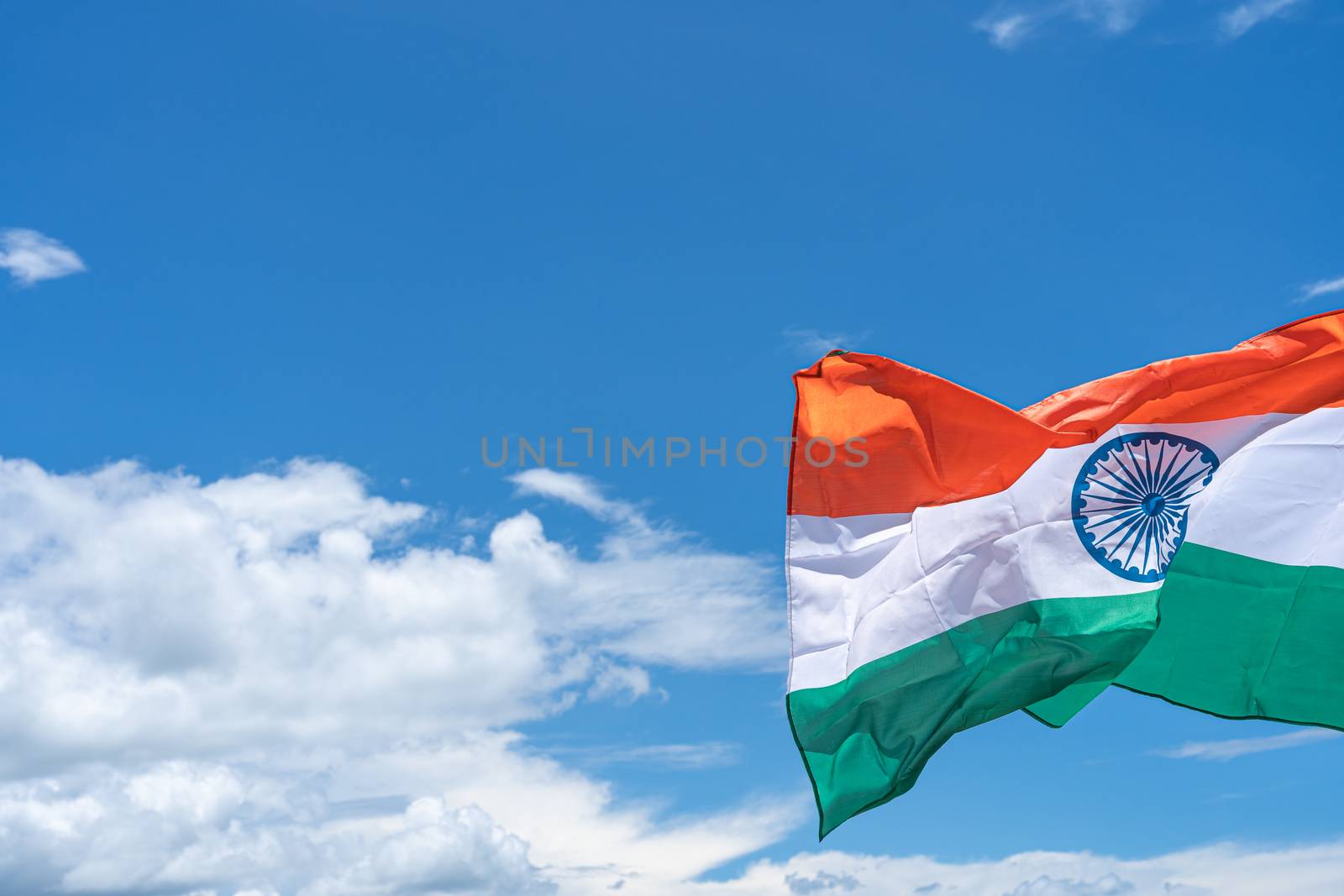 Waving India flag under blue sky background. by mikesaran