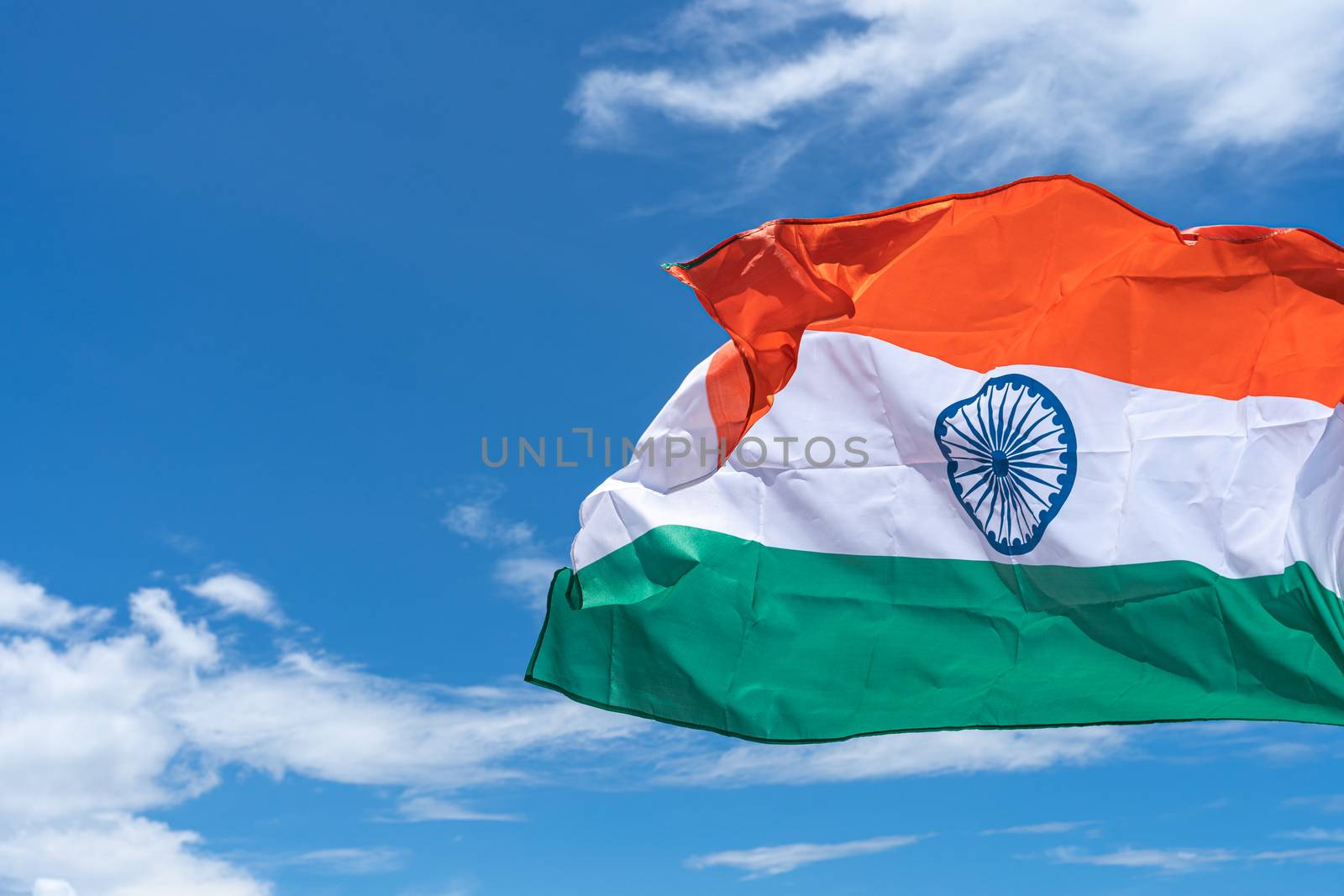 Waving India flag under blue sky background.