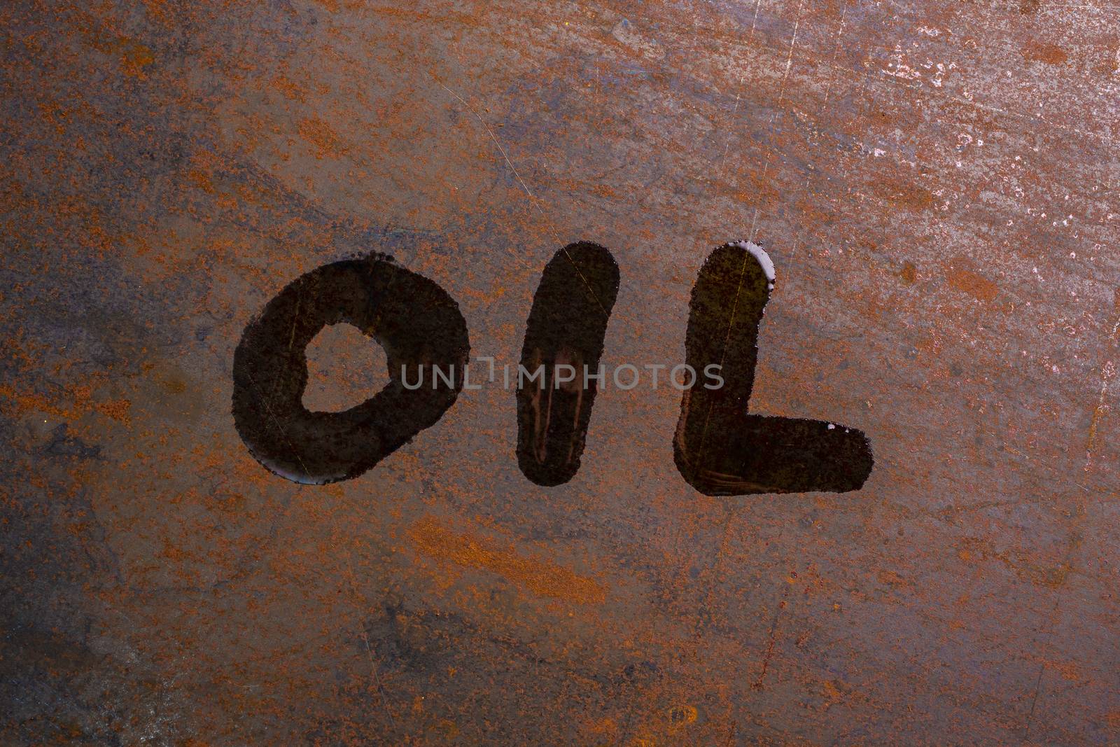 handwritten word oil on rusted sheet metal surface - close-up with selective focus conceptual photography