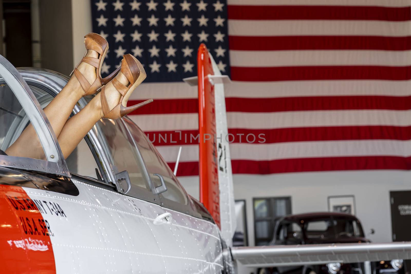 A beautiful blonde model poses with a vintage WWII aircraft