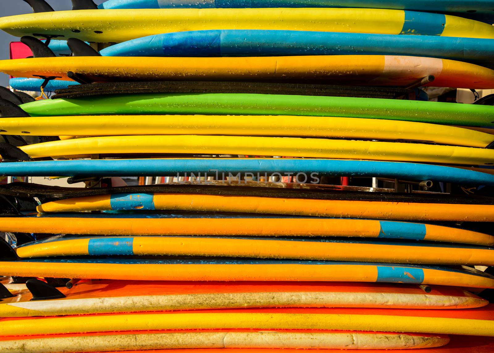 Stack of colorful surfboards by dutourdumonde