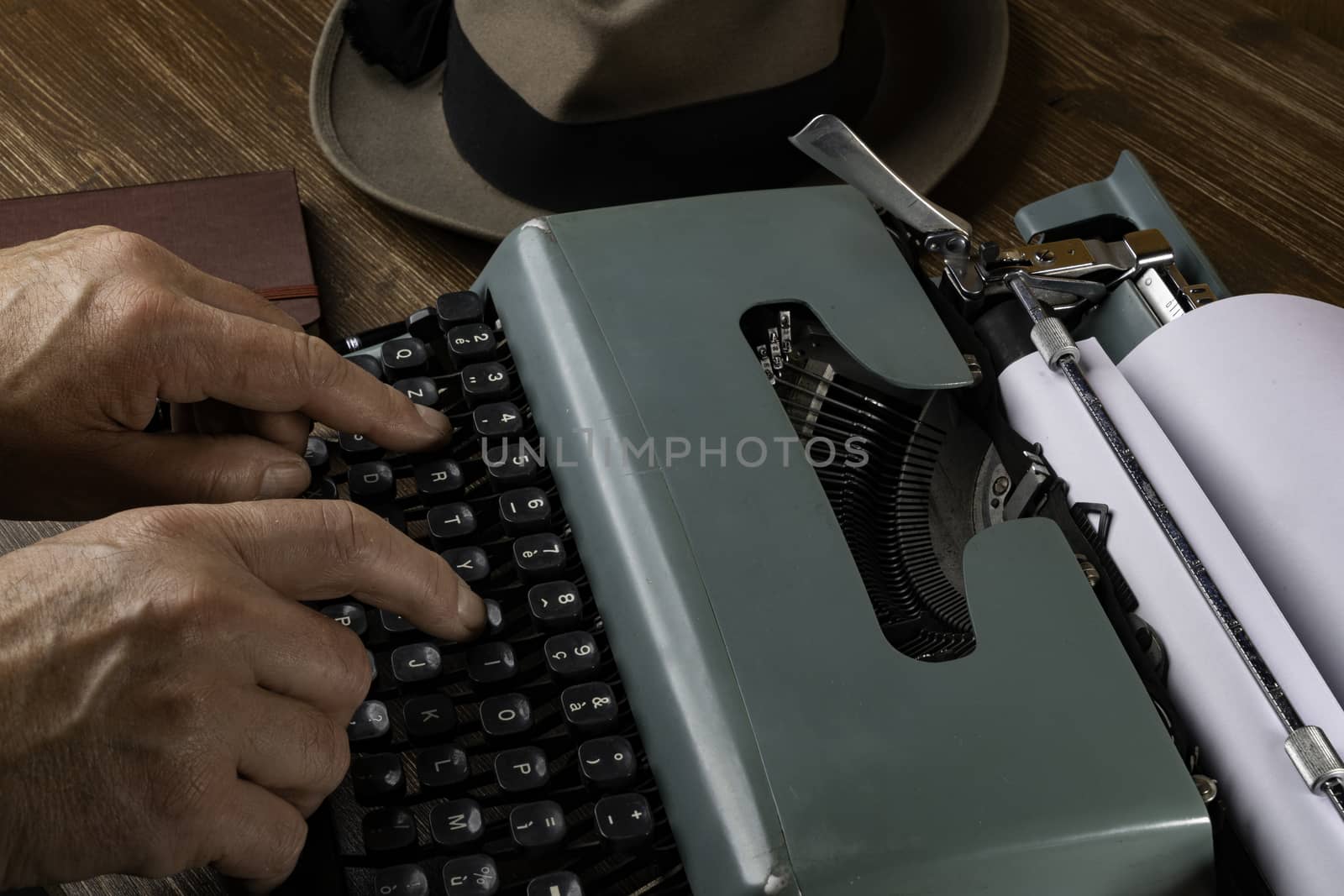 a man while writing with an old typewriter