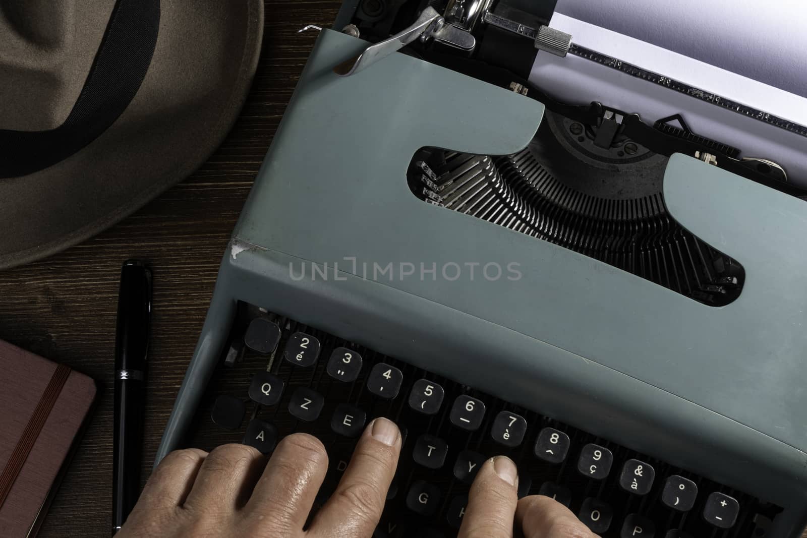 a man while writing with an old typewriter