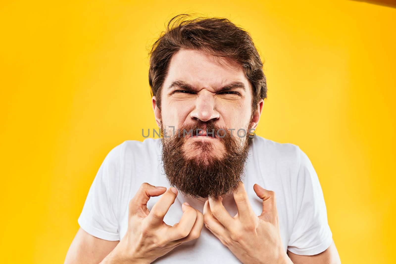 emotional bearded man gesturing with hands aggression discontent close-up yellow background by SHOTPRIME
