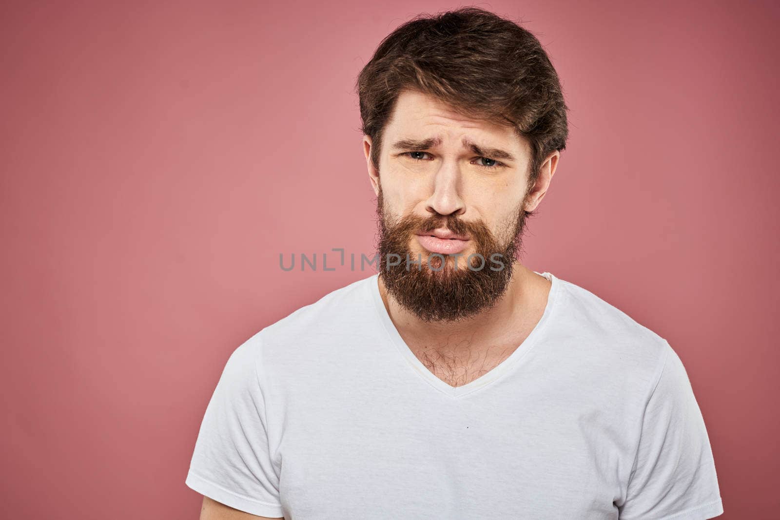 Man in white t-shirt emotions lifestyle facial expression cropped view pink background. by SHOTPRIME