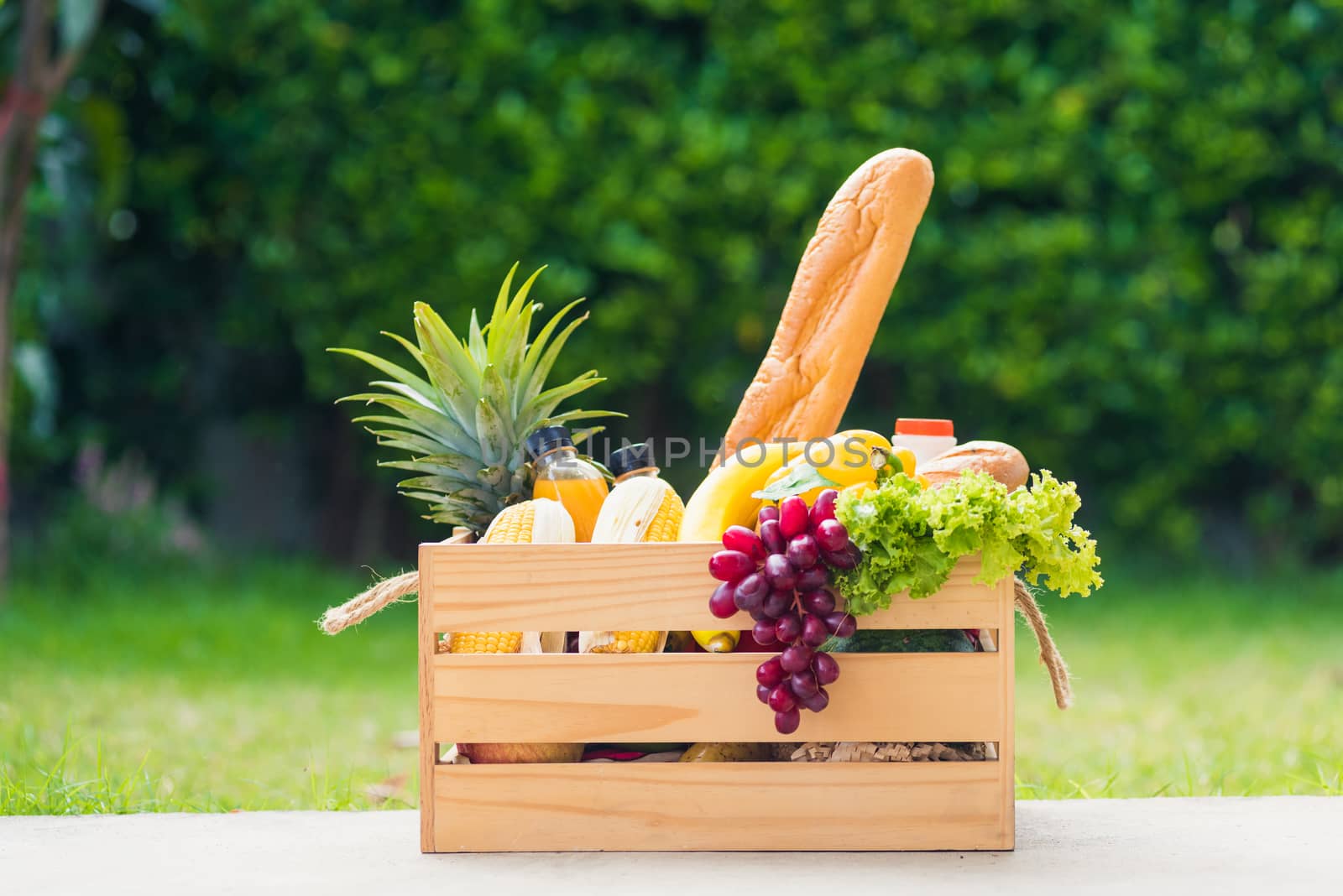 Full fresh vegetables and fruits in crate wood box, harvest organic food on the garden place of green leaves color background for copy space, Eat healthy concept