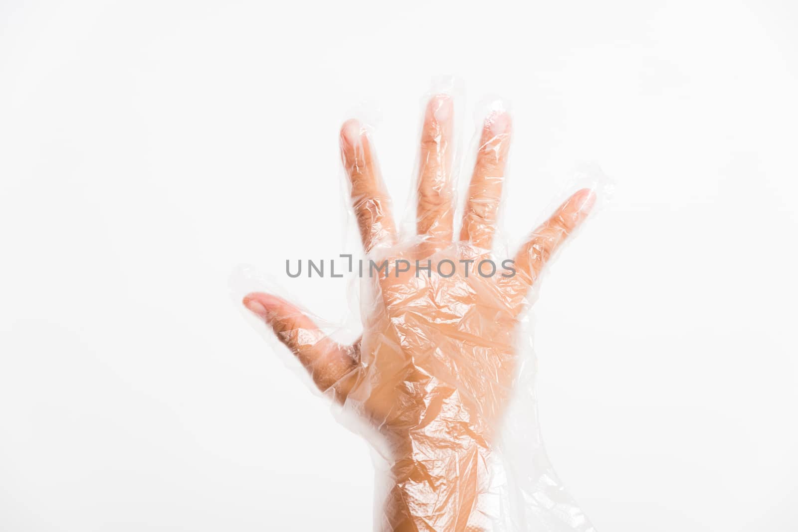 Woman hand wearing single use protect disposable transparent plastic glove, studio shot isolated on white background