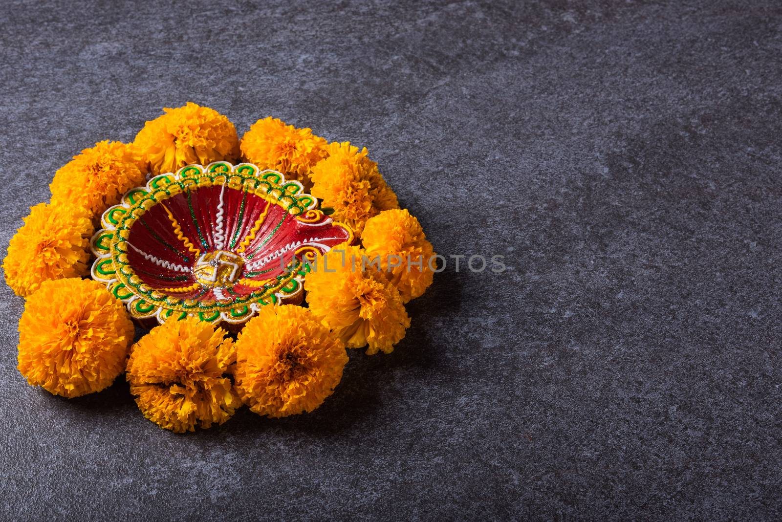 clay lit Diya or oil lamp and yellow flower by Sorapop