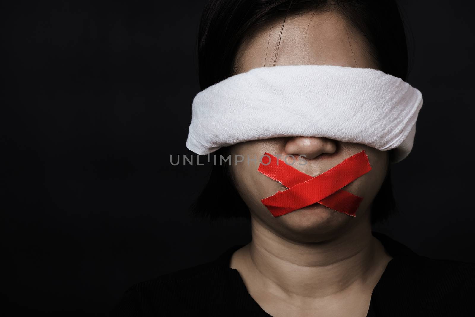 woman blindfold wrapping mouth with red adhesive tape, tied with by Sorapop