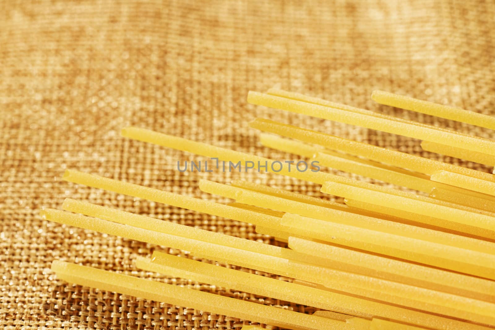 Dried pasta spaghetti on brown cloth ,long and thin solid cylindrical pasta