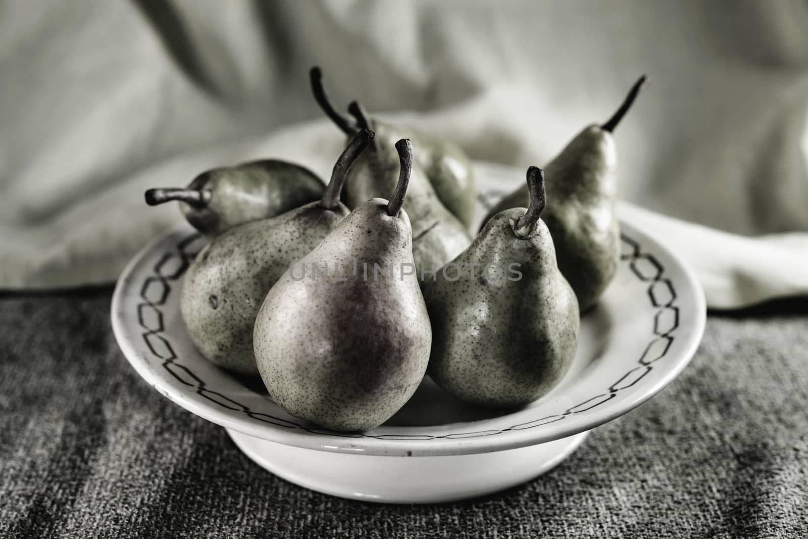 Beautiful pears  on a plate lying on a table ,desaturated colors